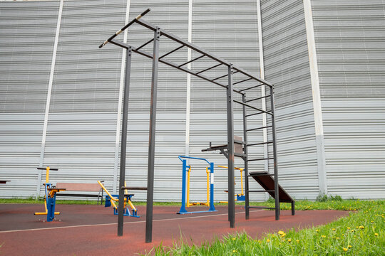 Multifunctional outdoor workout station with pull-up bars and exercise equipment. Calisthenics park for bodyweight training. Public fitness and strength training. Community exercise area.