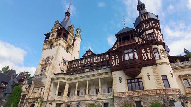 Panoramic view of the clock tower and ornate main facade of Peles Castle in Sinaia Romania
