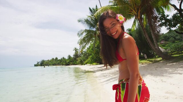 French Polynesia photo of woman wearing traditional pareo and Bikini relaxing on perfect beach on Bora Bora vacation travel. Completely unretouched, model has no makeup. Real people. Raw footage.
