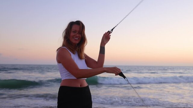 Attractive woman fire dancer spinning flames at the beach. Slow Motion.