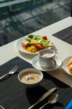 A Beautifully Arranged Breakfast Table with Delicious Plates of Food, Including Fresh Salad, Soup, and Coffee Set Against a Bright Window View