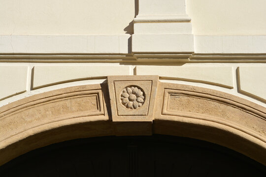 Close up view of a stone arch with a carved flower rosette keystone