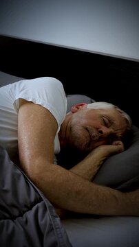 Mature adult sleeping at night. Vertical Video.