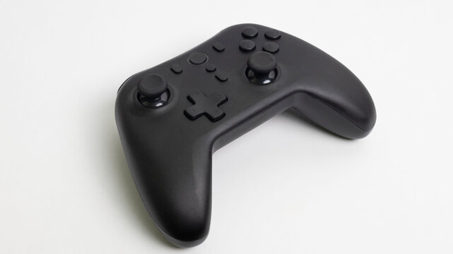 Black wireless game controller gamepad isolated on white background with copy space. Perfect for video game concept, gaming hardware, e-sports promotion, and entertainment industry.