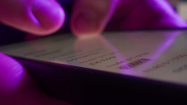 AI chat bot on phone, close up of hands typing prompt on smartphone screen in neon purple light, person using artificial intelligence assistant app at night
