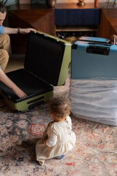 Baby watching father opening suitcase
