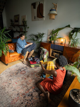 Multiracial couple packing suitcases for vacation