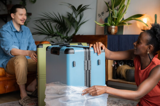 Couple checking new suitcases at cozy home.