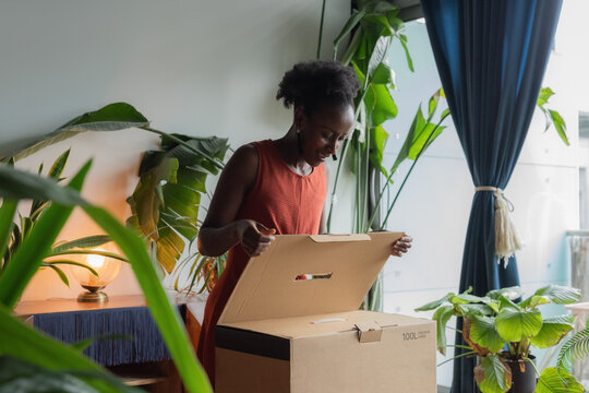 Woman opening box with online purchase at home