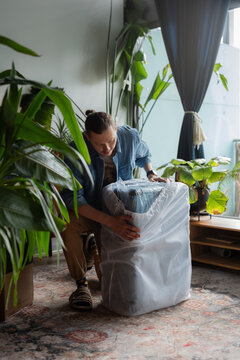 Man removes packaging from new suitcase