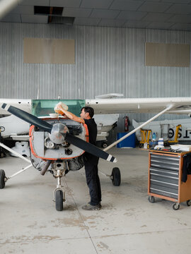 Mechanic is changing oil in aircraft engine