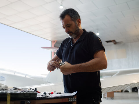 Mechanic in uniform is working at hangar