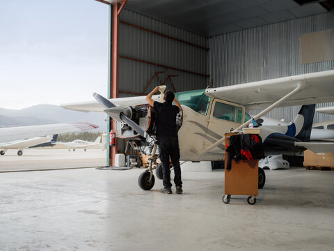 Man is changing oil in small aircraft