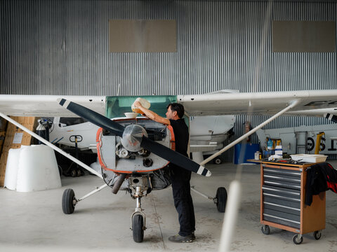 Man is servicing aircraft at hangar