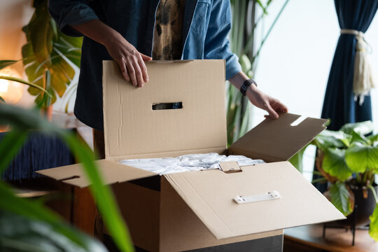Man opening box with new product at home
