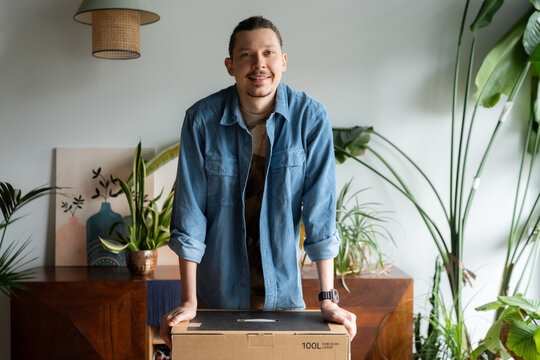 Man posing with package at home