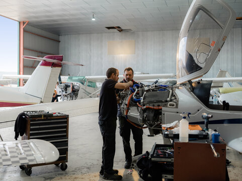Mechanic working with his colleague on aircraft maintenance
