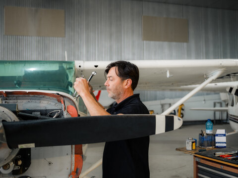 Mechanic using wrench tools in hangar