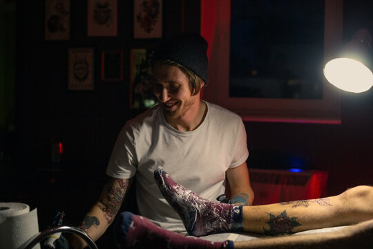 Tattoo artist smiling while working at studio