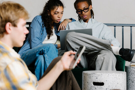 Diverse professionals working together with laptop in modern boardroom