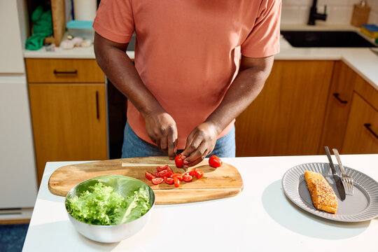 Man is chopping cherry tomatoes