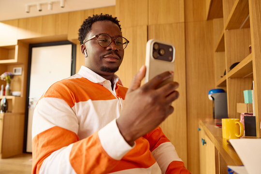 Portrait of a man smiles at his phone