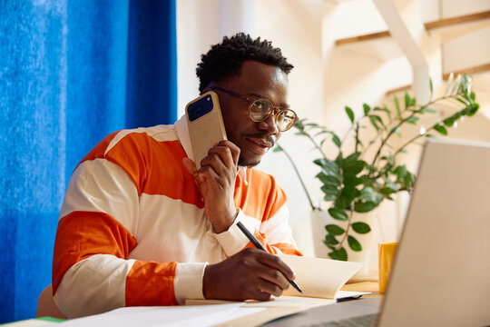 Man checking his laptop while on a phone call