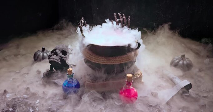 Steaming Halloween cauldron surrounded by glowing potions and skull.
