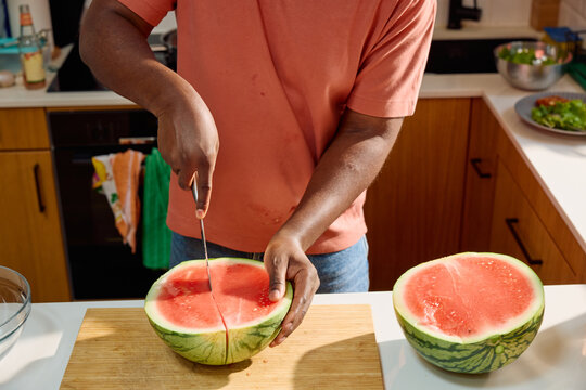 Man cuts a watermelon into pieces