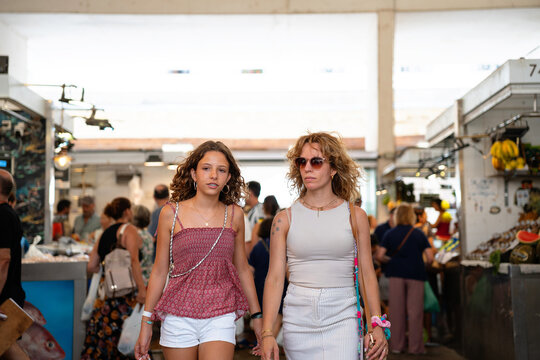 Mother And Daughter Walking Through a Market