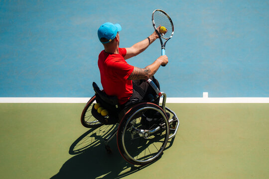 Wheelchair Tennis Player Serving On Outdoor Court