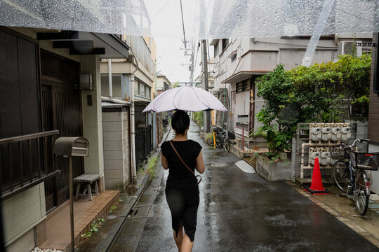 Woman Walking With Umbrella on Rainy Urban Street