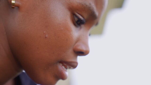 Close up profile view of woman with visible skin texture and gold hoop earrings. Mouth is slightly open revealing teeth closeup earring ear face side female