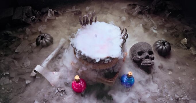 Smoking cauldron with colorful elixirs and dark pumpkin backdrop.