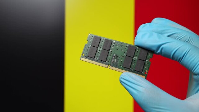 Close up view of hand in blue glove holding RAM memory microchip module. Belgian flag in blurred background. Concept of semiconductor shortage, artificial intelligence development in Belgium.