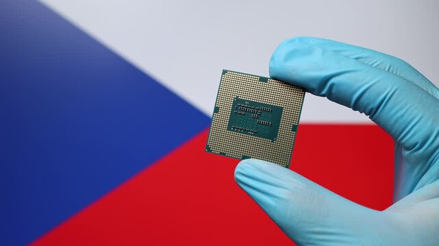 Close up view of hand in blue glove holding CPU microchip. Czech flag in blurred background. Concept of semiconductor shortage and artificial intelligence development in Czech Republic.