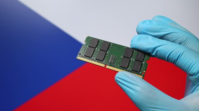 Close up view of hand in blue glove holding RAM memory microchip module. Czech flag in blurred background. Concept of semiconductor shortage, artificial intelligence development in Czech Republic.