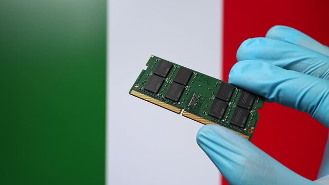 Close up view of hand in blue glove holding RAM memory microchip module. Italian flag in blurred background. Concept of semiconductor shortage, artificial intelligence development in Italy.
