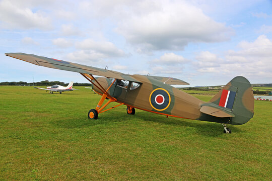 Vintage military airplane standing on a grass runway	