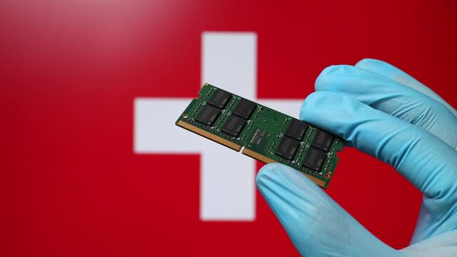 Close up view of hand in blue glove holding RAM memory microchip module. Swiss flag in blurred background. Concept of semiconductor shortage, artificial intelligence development in Switzerland.