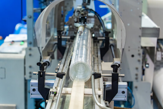 Stack of polypropylene cup on conveyor belt of automatic plastic injection molding machine,automated technology concept