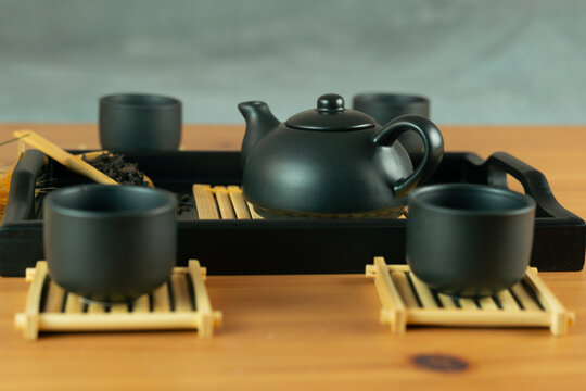 chinese tea ceremony gongfu tea set chahu teapot pinming cups chaban tray, front view on wooden table with gray background and copy space for banner design concept of tea culture, restaurant