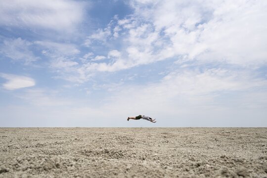 Abstract, man jumping horizontally at the Etosha pan, salt pan, Etosha National Park, Namibia