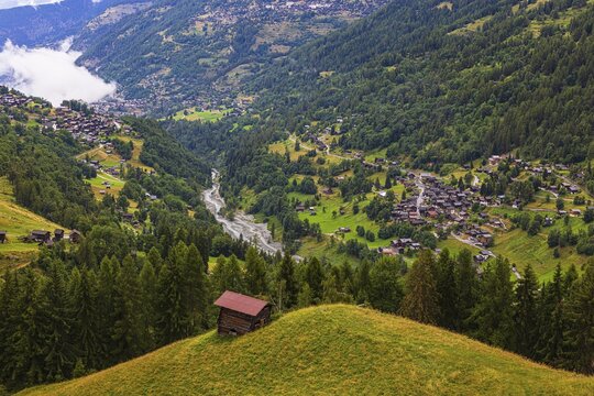 Small mountain hut on a green hill, with the villages of Mission and Saint Jean behind, Val d'Anniviers, Valais Alps, Canton Valais, Switzerland
