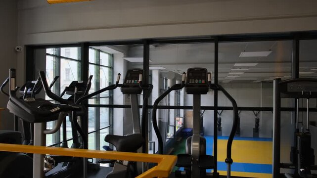 Empty cardio zone inside a modern fitness club with elliptical trainers and exercise machines, suitable for gym business, endurance training, wellness, healthy lifestyle, rehabilitation and indoor spo
