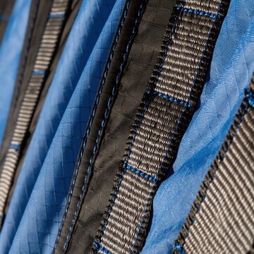 Ripstop technical fabric and nylon webbing with precise stitching, showing a crisp cobalt blue and grey texture for industrial backgrounds