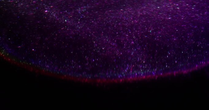 Blur cosmos glitter. Sparkling glare. Purple blue neon color shiny rainbow radiant texture floating on abstract dark black lilac art background.
