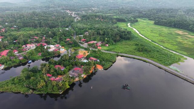 Aerial view of a serene lake with a small island village at Tasik Raban