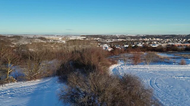 Aerial Drone Shot of Snowy Winter Landscape in the Czech Countryside. Snow-Covered Fields and BAre Trees during a Cold Daytime.