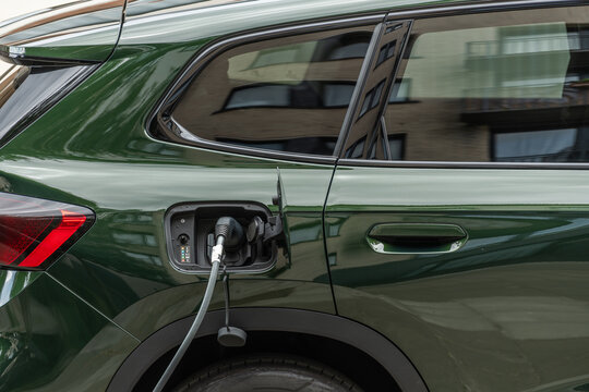Brussels, Belgium. Electric vehicle charging with cable connected to battery powered car